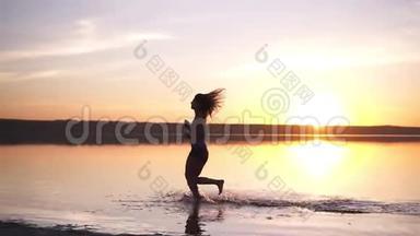 有长发的苗条女人在户外跑步。 在水边慢跑。 海边。 太阳照耀着背景